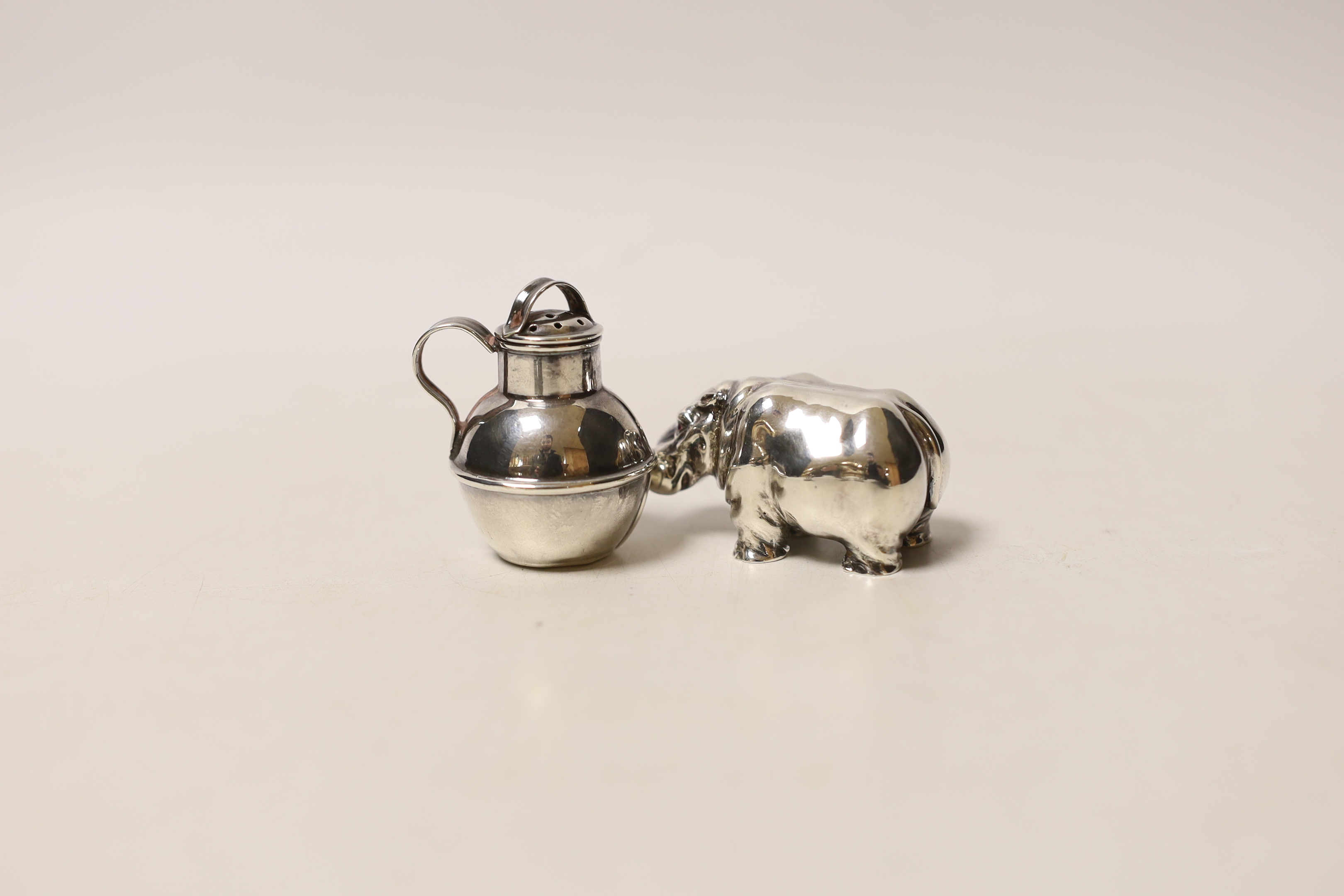 A modern silver miniature model of a hippopotamus, a white metal 'Guernsey can' pepperette and a part of a late Victorian silver small chamberstick.